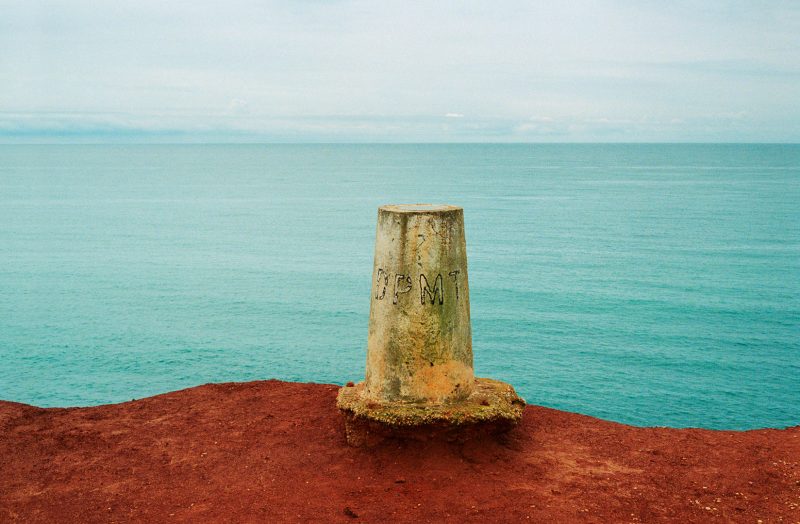 coastal cliff marker near sea, Spain, showing soil erosion